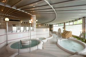 un ampio bagno con due vasche idromassaggio di Hotel Morinokaze Tateyama‎ a Toyama