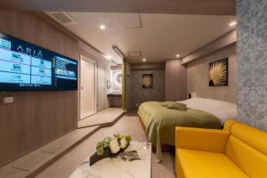 a hotel room with a bed and a tv at HOTEL ARIA-Yokohama Kannai in Yokohama