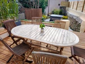 a wooden table with chairs and a potted plant on a patio at Maison Corse avec SPA - La Casa Serena in Ortiporio
