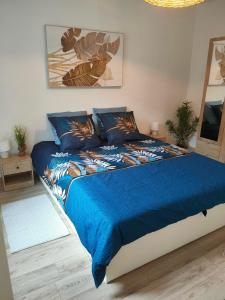 a bedroom with a bed with a blue comforter at Maison Corse avec SPA - La Casa Serena in Ortiporio