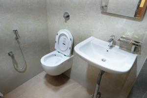 a bathroom with a toilet and a sink at Kailash Residency in Hospet
