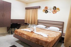 a bedroom with a bed with teddy bears on the wall at Kailash Residency in Hospet +4 photos