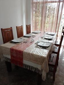 a dining room table with plates and glasses on it at Charlotte Inn in Kandy