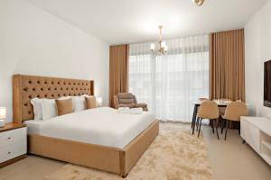 a bedroom with a large bed and a dining room at FIRST CLASS Studio Pacific Shores Retreat in Ras al Khaimah +19 photos