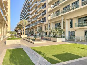 a large apartment building with a lawn in front of it at FIRST CLASS Studio Pacific Shores Retreat in Ras al Khaimah