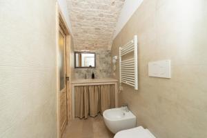 a bathroom with a toilet and a sink at Himeros Trulli Area in Alberobello +19 photos