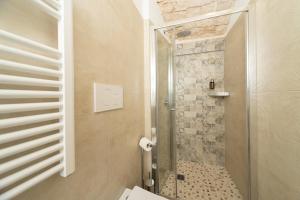 a bathroom with a shower with a glass door at Himeros Trulli Area in Alberobello