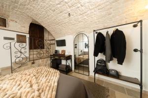a bedroom with a bed and a mirror at Himeros Trulli Area in Alberobello