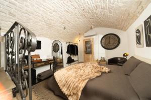 a bedroom with a bed and a clock on the wall at Himeros Trulli Area in Alberobello