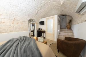 a living room with a staircase and a chair at Himeros Trulli Area in Alberobello
