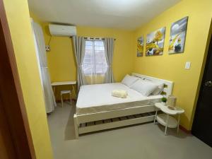 a bedroom with a bed in a yellow room at Casa Solana at Malaybalay VCDU Phase 3 B4 L22 in Malaybalay +29 photos