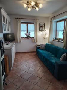 a living room with a green couch and two windows at Casa vacanze tortoi in Candide