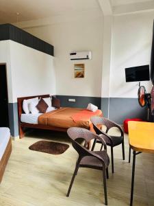 a bedroom with a bed and two chairs and a table at Dolape Villa in Ella