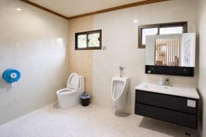 a bathroom with a toilet and a sink and a urinal at วลัญชญ์ โฮเทล ศรีราชา in Ban Nong Chaeng