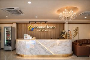a hotel lobby with a reception counter and a chandelier at วลัญชญ์ โฮเทล ศรีราชา in Ban Nong Chaeng