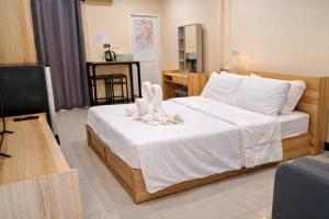 a bedroom with a bed with towel animals on it at วลัญชญ์ โฮเทล ศรีราชา in Ban Nong Chaeng