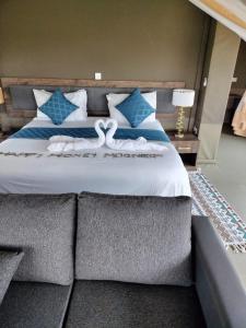 a bedroom with a bed with two swans on it at Oloimala Mara Camp in Gatunga +21 photos