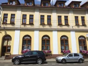due auto parcheggiate di fronte a un edificio di Hotel Max Šimek a Ostrava