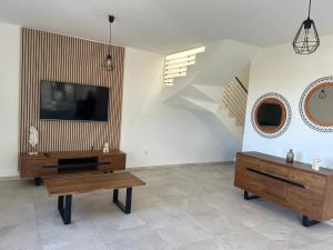 a living room with a tv and a table and stairs at Villa chandelle in Saint-Pierre