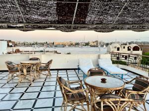 a patio with tables and chairs and a view of the water at Qasr El Nil in Luxor