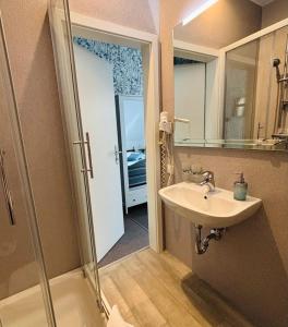 a bathroom with a sink and a shower with a mirror at Am Wasserturm Pension in Bad Muskau +26 photos
