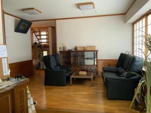 a living room with two chairs and a table at つむぐ家2 in Ueda
