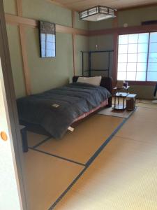 a bedroom with a bed in the corner of a room at つむぐ家2 in Ueda