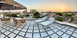a patio with chairs and tables on a roof at Qasr El Nil in Luxor