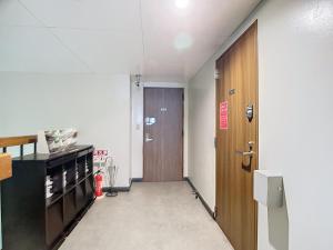 an empty hallway with a door and a red fire hydrant at キュリナリーBed and Art in Hamamatsu