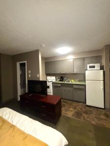 a kitchen with a bed and a kitchen with a refrigerator at Rainbow INN in Terrace