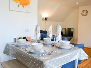 a table with a white table cloth with dishes on it at 3 Old Posting Stables in Gatehouse of Fleet