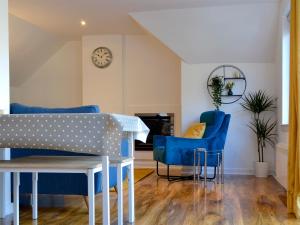 a dining room with blue chairs and a table at 3 Old Posting Stables in Gatehouse of Fleet