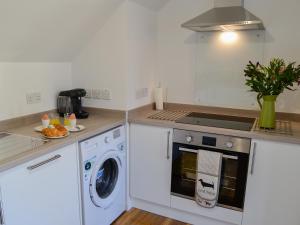 a kitchen with a washing machine and a washer at 3 Old Posting Stables in Gatehouse of Fleet