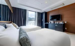 a hotel room with two beds and a television at 브라운도트호텔 인천 송도 Browndot Hotel Incheon Songdo in Incheon +73 photos