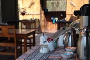 a table with a coffee pot and cups on it at Mukuku Oasis Lodge in Shimweghe