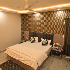 a bedroom with a large bed and a ceiling at Mithila Resort in Jāmb
