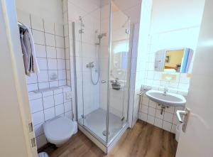 a bathroom with a shower and a toilet and a sink at Hotel Fidelitas in Bad Herrenalb +51 photos