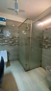a bathroom with a glass shower and a toilet at Mitron Farms in New Delhi