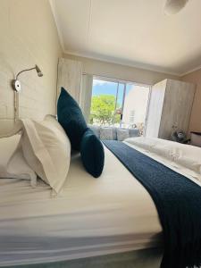 a bedroom with a large bed with blue pillows at WestBed in Langebaan