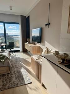 a living room with a couch and a tv at Baltic Infinity Suite 529 - SPA & Pool Access in Międzyzdroje