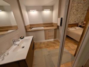 a bathroom with a sink and a mirror and a bed at Chambres d'hôtes - Le Mas du Colombeyras in Espeluche +37 photos