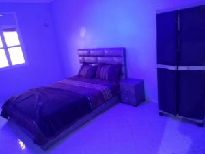 a purple bedroom with a bed and a window at شقق الخيالي 2 in Tan-Tan