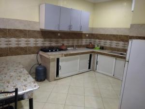 a small kitchen with white cabinets and a refrigerator at شقق الخيالي 2 in Tan-Tan