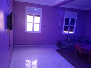 a living room with purple walls and a window at شقق الخيالي 2 in Tan-Tan