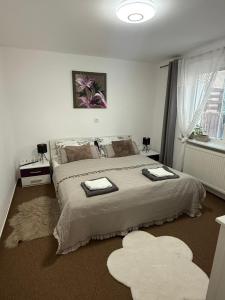 a bedroom with a large bed with two towels on it at Ubytovanie Dana in Piešťany