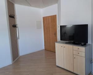 a living room with a flat screen tv on a cabinet at Haus Probst in Bischofsmais