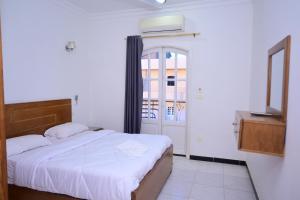 a bedroom with a white bed and a window at Qasr El Nil in Luxor +80 photos