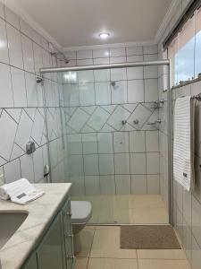 a bathroom with a shower with a toilet and a sink at Suíte de Casal Privativa com Sacada in Sao Jose do Rio Preto