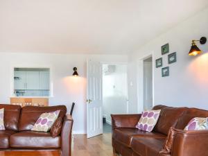 a living room with two brown leather couches at Harbour View in Cemaes Bay