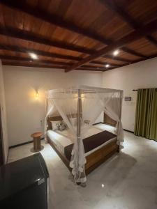 a bedroom with a bed with a canopy at The villa Evans in Pitiduwa +19 photos
